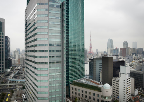 Tokyo, Japan - February 12, 2011: Cityscape view of the urban Ginza district and Tokyo Tower on a cloudy winter day. Shot from the 16th floor lobby of the Mitsui Garden Hotel.