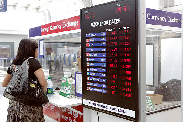 femme devant le kiosque de change pour devises étrangères - airport usa business ohare airport photos et images de collection