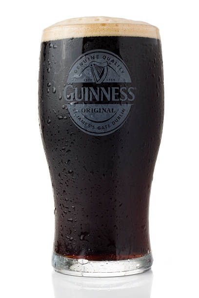 холодного пива из гиннесс изолированные на белом фоне - guinness стоковые фото и изображения