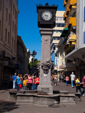 San Jose, Costa Rica - March 1, 2009: Clock and fountain in a pedestrian zone in the city centre of San Jose. People can be seen walking about this area which is a shopping district.
