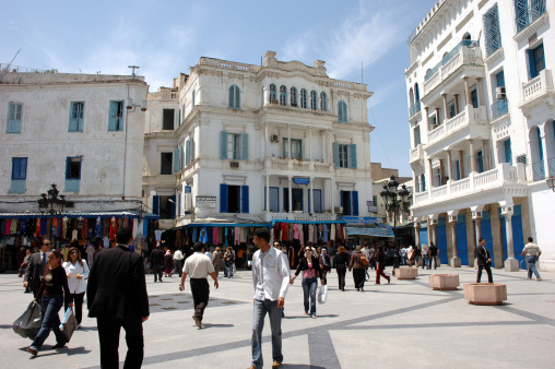 Tunis, Tunisia - May 8th, 2006: People walking around on an ordinary day in the main square leading to La Medina; famous marketplace of Tunis.
