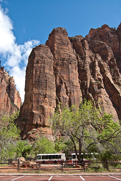 Shuttle Buses Wait for Passengers in a National Park Zion National Park, Utah, USA - May 10, 2011: A system of free shuttle buses helps to limit visitor impact in the national park. jeff goulden zion national park stock pictures, royalty-free photos & images