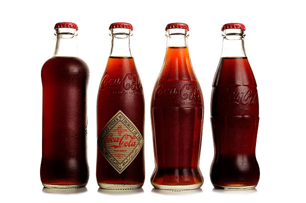 Close-Up Of Multi Colored Drink Bottles Against White Background