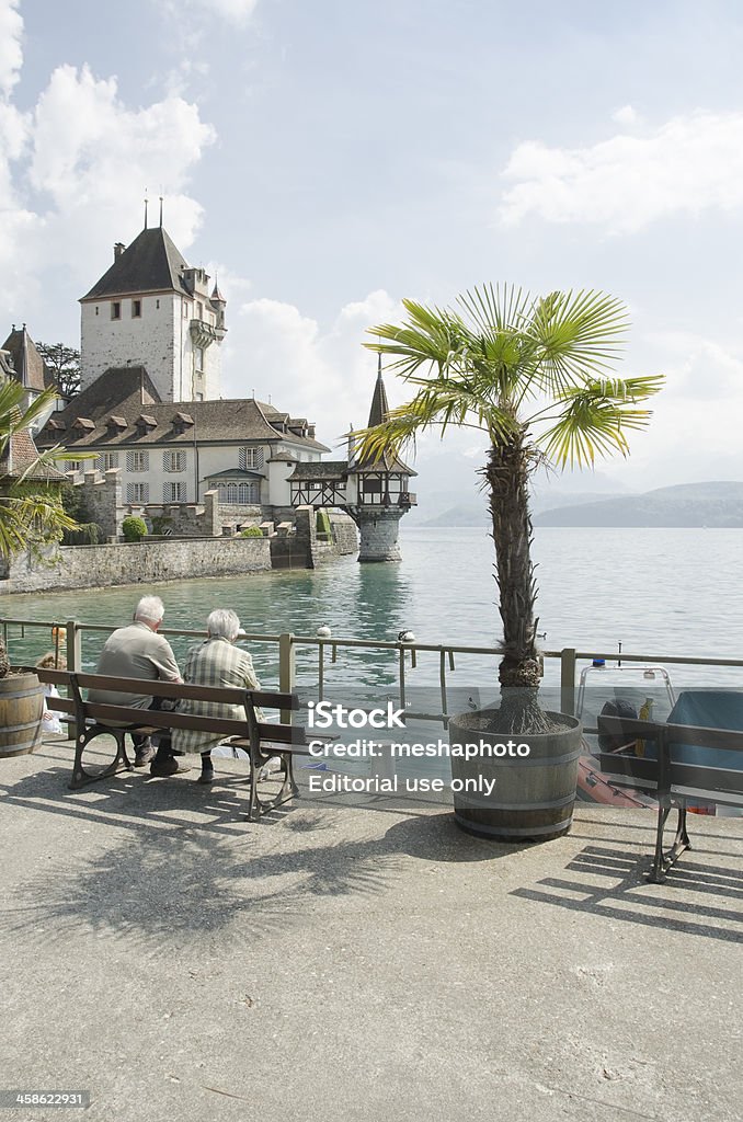 Oberhofen Castle on Lake Thun, Switzerland "Thun, Switzerland - April 24, 2011: Senior couple traveling through Switzerland and enjoying the view of Oberhofen Castle on Lake Thun." Active Lifestyle Stock Photo