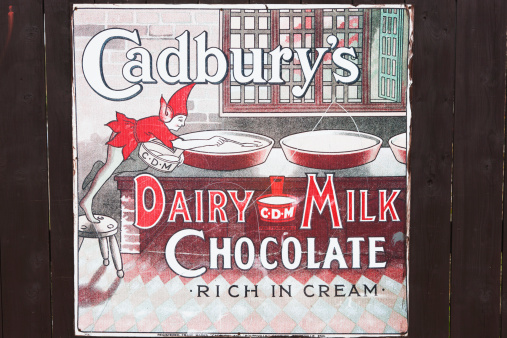 Glasgow, UK - September 30, 2011: An old advertisement from the 1920s attached to a wooden hoarding advertising Cadbury's Dairy Milk Chocolate.