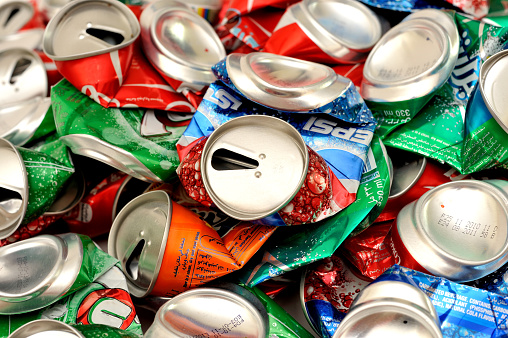 Dubai, United Arab Emirates - June 11, 2011: Heap of crushed metal cans with brand-name labels of common drinks. The cans contained coca cola,pepsi 7 ups, Sprite. 