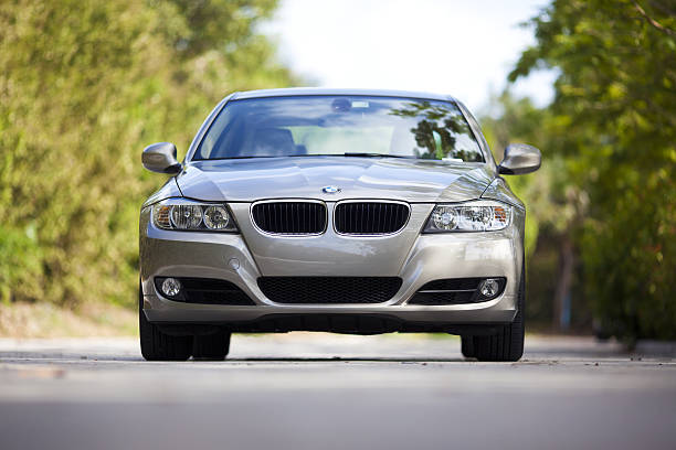 BMW 3 Series 328 Miami, USA - March 21, 2010, BMW 3 series (328) bronze color is parked on a small road in Miami, front view from a laying position. 2010 stock pictures, royalty-free photos & images