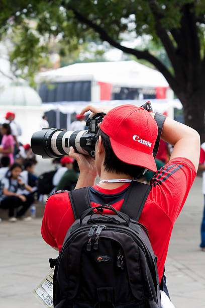 Canon Photographer Jakarta, Indonesia - October, 10 2009:  Canon Photographer taking a photograph with a professional camera during the Canon Photomarathon Indonesia 2009 organised in Jakarta old town. sports photography stock pictures, royalty-free photos & images