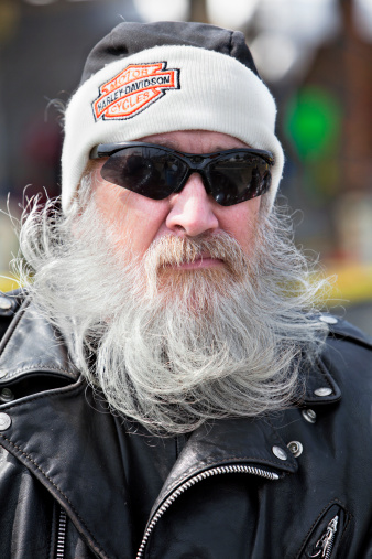 Daytona, Florida,USA - March 7, 2011: Senior Biker Decked out in Harley Davidson Leathers  standing by his bike at the 70th Annual Daytona Bikeweek. One of the countries biggest motorcycle events of the year.