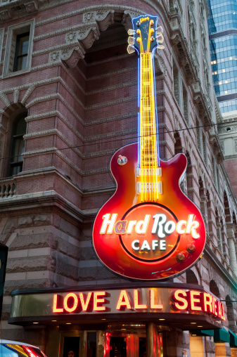 Philadelphia, USA - June 17, 2011. Illuminated neon sign \'Love all - Serve all\' and guitar of the Hard Rock Cafe in the Philadelphia downtown.