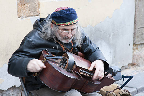 Street Musician playing the Hurdy Gurdy in Prague Prague, Czech Republic - October 21, 2011: A street musician plays a musical instrument called the Hurdy Gurdy in one of the streets in Prague. hurdy gurdy stock pictures, royalty-free photos & images