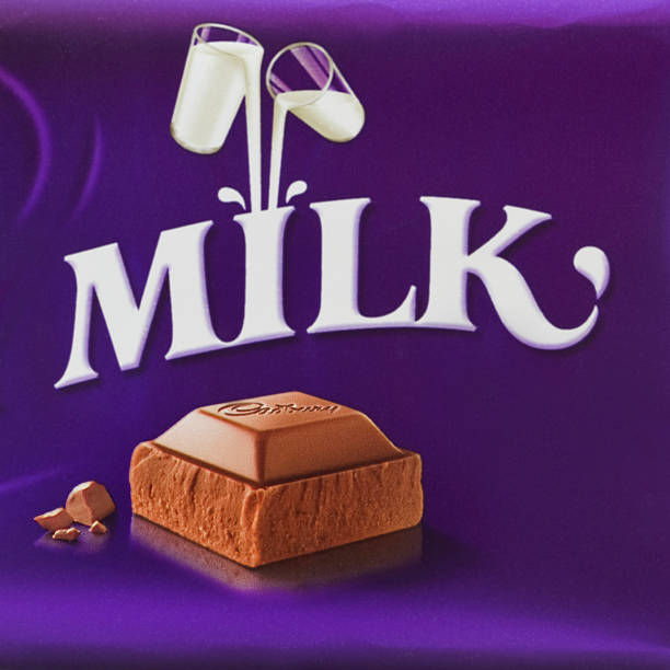 cadbury dairy milk chocolate bar wrapper London, England - March 2, 2011: The Cadbury Dairy milk chocolate bar was first produced in the UK in 1905 and had more milk content than its competitors and Cadbury invented the slogan aa a glass and a half.  It became the top seller for Cadbury and has a distinctive purple wrapper. It is one of the worlds best selling chocolate brands. cadbury plc photos stock pictures, royalty-free photos & images