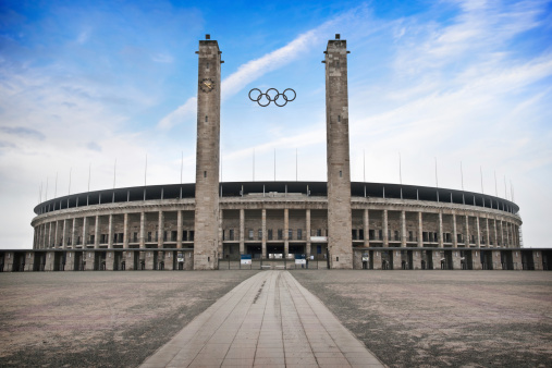 Berlin, Germany - February 23, 2010: Monumental Olympic Stadium (Olympiastadion) in Berlin under bright blue sky, which was built for the 1936 Summer Olympics. On the image is the main entrance.