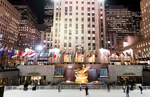 New York, United States - January 11, 2012: People ice skating at the Rockefeller Center in New York. The Rockefeller complex with 19 buildings in Midtown Manhattan  spans between the fifth and sixth avenue and is considered a national historic landmark. The Ice skating rink was placed for the first time in 1936 and is a place were new yorkers gather to have a good time.