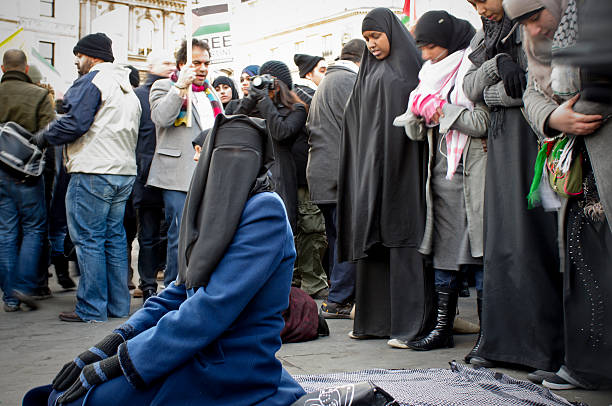 donna musulmana pregare in trafalgar square, londra - protest editorial people travel locations foto e immagini stock