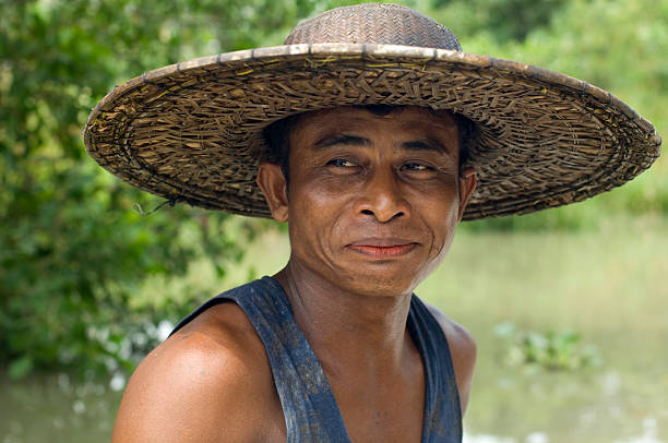 Rangoon, Myanmar, April 24, 2009: A fisherman is driving in his boat on a river. He is very poor and has to provide food for his family by fishing in the river.