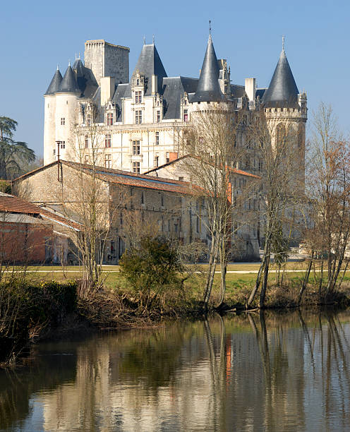 Chateau Rochefoucauld France "Rochefoucauld, France - February 16, 2008: Chateau Rochefoucauld.The original fortress was built in the 11th Century and was subsequently restyled as a Chateau in the Renaissance style. It overlooks the River Tardoire, shown in the foreground of the image. The building is open to the public with over twenty rooms available for viewing and is a popular  attraction for tourists in the region." angouleme stock pictures, royalty-free photos & images