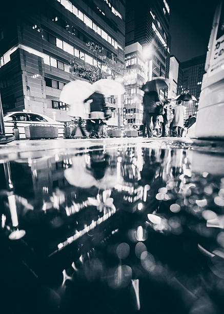 Rainy night in big city. Tokyo, Japan - October 28, 2010: People with umbrellas walking fast through rainy streets of Hamamatsucho district. low angle street japan stock pictures, royalty-free photos & images