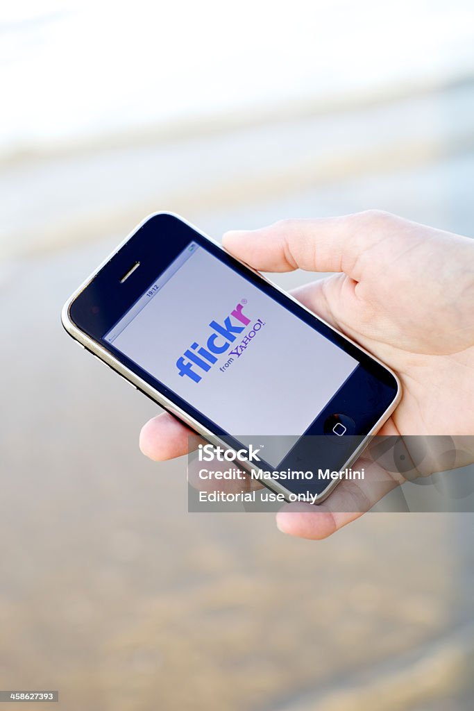 Flickr On iPhone Ravenna, Emilia-Romagna, Italy - August 20, 2011: Close up of a human hand connecting to Flickr on iPhone, a smart phone produced by Apple Inc. Flickr was developed by Ludicorp, a Vancouver-based company, and launched in February 2004. Apple Computers Stock Photo