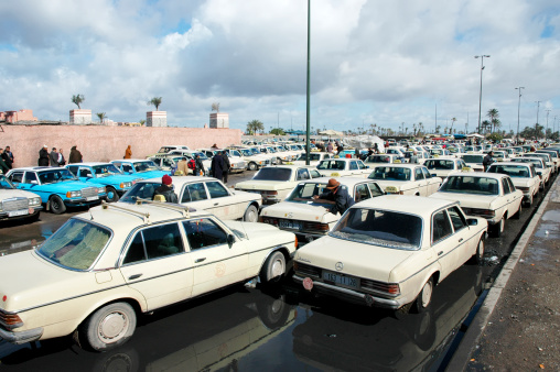 Marrakech, Morocco - February 22, 2006: Very big taxistand in Marrakech short after a heavy storm. It is ouside the doors of the famous Marrakech souk. Most of the taxis are very old Mercedes Benz.
