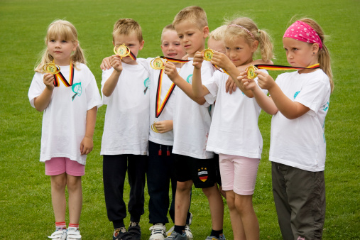 Torgau, Germany - June, 2008: Small group of children on a sports event for preschoolers posing for the photographers after they won the team competition. Annual sports event for all regional kindergartens.