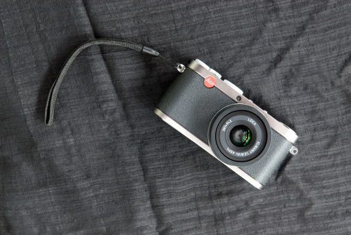 Paris, France - May, 07 2011:compact camera Leica X1 lay on a black tissu.