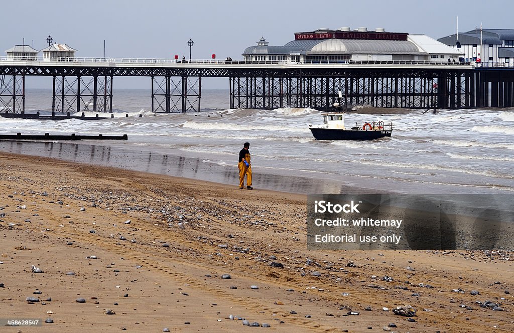 Pescatore con barca su Cromer beach Norfolk - Foto stock royalty-free di Bagnato