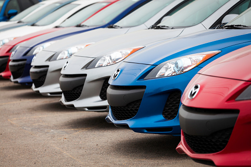 Truro, Nova Scotia, Canada - March 25, 2012: Various colors of new Mazda 3 vehicles sit in a row on a car dealership lot displaying the front fascia of the vehicles.  The Mazda 3 is a hatchback vehicle manufactured by Mazda.  Known as the Alexa in Japan is was introduced as a 2004 model.  Model pictured is the current and second generation of the Mazda 3 (as of May 2012).