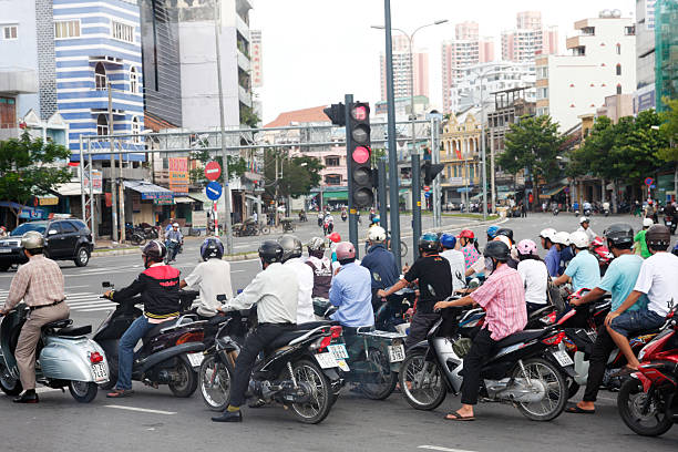 Ho Chi Minh, Vietnam - May 22, 2011: Motorcycles riders stopped at red light in Ho Chi Minh city. Very high numbers of motorcycles and scooters are dominating the traffic of town