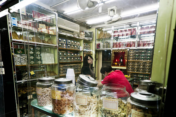 MACAU, CHINA - September 30, 2011: People inside traditional chinese pharmacy selling mainly herbal and other natural remedies in Macau. With over 13000 medicinals and more than 100.000 recipes this type of alternative medicine is very popular.