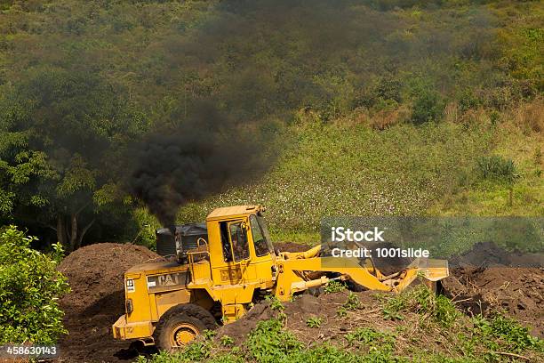 Foto de Carregando Está Trabalhando Na Natureza Com Fumaça e mais fotos de stock de Buldôzer - Buldôzer, Uganda, Atividade