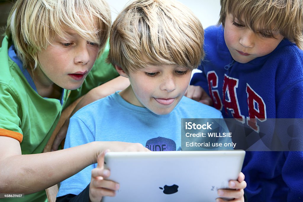 Trois enfants à la recherche à l'écran sur iPad2 - Photo de Agenda électronique libre de droits