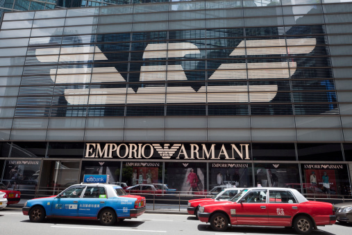 Hong Kong, China - July 22, 2011: Pedestrian and traffics pass the road in front of the Emporio Armani flagship store. This store is located in Connaught Road, Central, Hong Kong. This is the world\'s second-biggest Armani store, after one on Via Manzoni in Milan.
