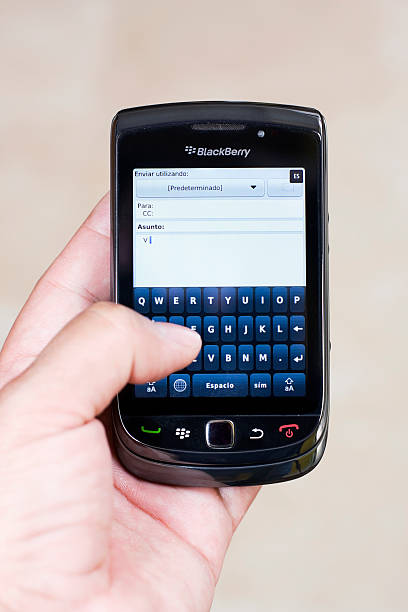 blackberry torch tippen spanischer sprache - blackberry mobile phone smart phone human hand stock-fotos und bilder