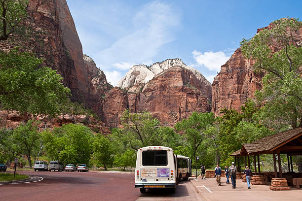 Park Visitors Wait to Board the Shuttle Buses Zion National Park, Utah, USA - May 10, 2011: A system of free shuttle buses helps to limit visitor impact in the national park. jeff goulden zion national park stock pictures, royalty-free photos & images