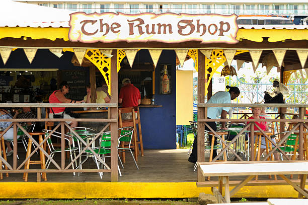 Castries, Saint Lucia- January 24th, 2008: Cruise ship passengers having drinks in the rum shop located at Pointe Seraphine by the port in Castries, Saint Lucia. A cruise ship is in the background.