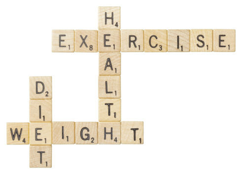 Sacramento, California, USA - February 9, 2012: Scrabble game tiles form words relating to diet and health: health, exercise, diet, and weight. Scrabble is a registered trademark of Hasbro, Inc.