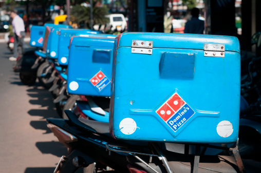 Panjim, India - January 13, 2011: Dominos Pizza delivery bikes parked in a row in Panjim, Goa, India. Dominos Pizza is a worldwide Pizza chain. Listed on the New York Stock Exchange today, it was founded in the 1960s in the USA. Panjim is Goa's capital city in Southern India.