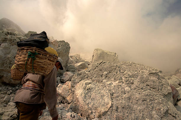 Miner carrying sulphur (Kawa Ijen, Java) stock photo