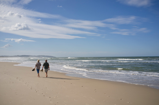 Lennox Head, NSW, Australia - May 8, 2011: A middle aged couple take an afternoon walk along Seven Mile Beach at Lennox Head, Australia