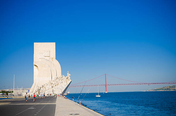 Lisbon, Portugal - August 9, 2011: The Padrão dos Descobrimentos, also known as Monument to the Discoveries, sits along the banks of the Tagus River in Lisbon celebrating Portugal\\'s age of discovery during the 15th and 16th centuries, with the April 25th Bridge in the distance.