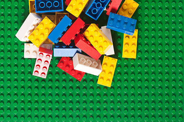 скатанный lego блоков кирпича на зеленой baseplate - lego toy close up characters стоковые фото и изображения