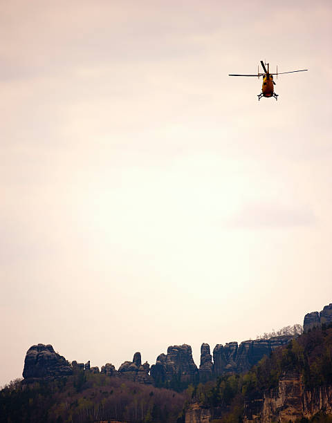 ADAC rescue helicopter Schmilka, Germany - April 17, 2011: german ADAC (Allgemeiner Deutscher Automobil-Club) rescue helicopter in saxon switzerland (elbsandsteingebirge) during a rescue operation; these helicopters are sometimes called "yellow angel" ( "gelbe Engel") adac stock pictures, royalty-free photos & images