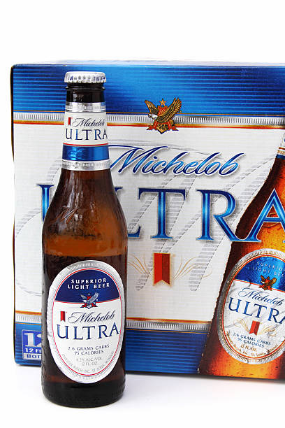 Bottle of Michelob Ultra light beer West Palm Beach, USA - January 23, 2011: Bottle of Michelob Ultra light beer, manufactured by Anheuser Busch Inc. Cold beer in moist bottle from condensation. Bottle is set in front of a cardboard twelve pack of beer. Michelob Ultra stock pictures, royalty-free photos & images