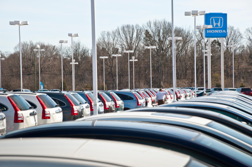 Knoxville, Tennessee, USA - February 13, 2011:A customer at a Honda car dealership walks along on the lot examining different Honda vehicles.  The vehicles along the left row are Honda CRV SUV\'s, while the cars in the immediate foreground are Civics.