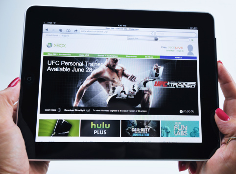 Raleigh, NC - USA - June 27, 2011: Woman Holding an iPad Displaying UFC PErsonal Trainer Xbox Video Game.