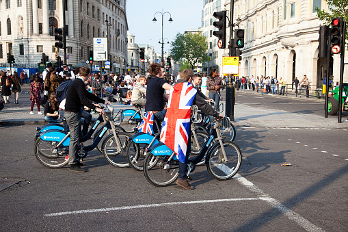 London, UK - April 29, 2011: A group of young people on bikes waiting for the green light to pass the street on the day of the Royal Wedding.
