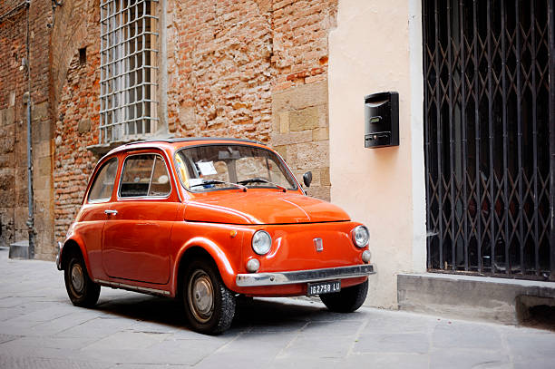 Vintage Fiat 500 Lucca, Italy - June 27, 2011: Vintage Fiat 500 parked in a street in the medieval town of Lucca, Italy. A compact and affordable two door town car, the Nuova 500 was manufactured by Fiat between 1957 and 1975. little fiat car stock pictures, royalty-free photos & images