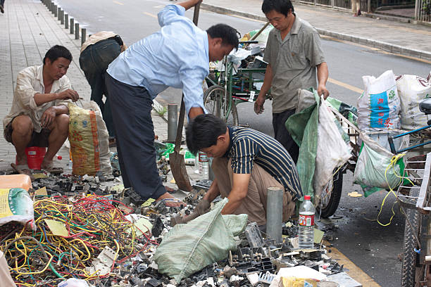 Trabajadores pobres de China de desmontaje de dispositivos eléctricos en la calle - foto de stock