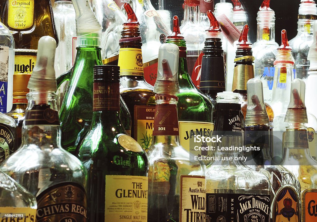 Alcoholic Pourers Sandwich, Massachusetts, United States - June 26, 2008: Group of bottles at the back of a bar in Sandwich, Massachusetts. Scotch and malt whisky, Bourbon and other drinks, some fitted with pourers. Alcohol - Drink Stock Photo